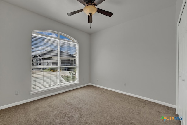 carpeted spare room with a wealth of natural light and ceiling fan