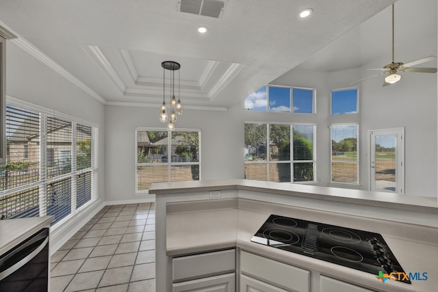 kitchen with black appliances, white cabinets, ornamental molding, light tile patterned floors, and a tray ceiling