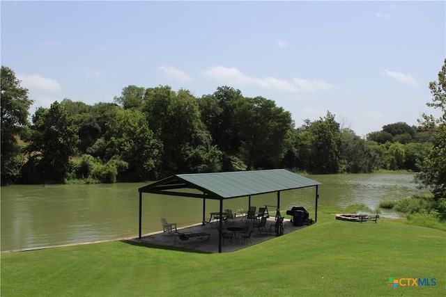 view of dock with a gazebo, a water view, and a lawn