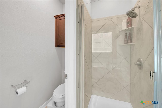 bathroom with toilet and a shower stall