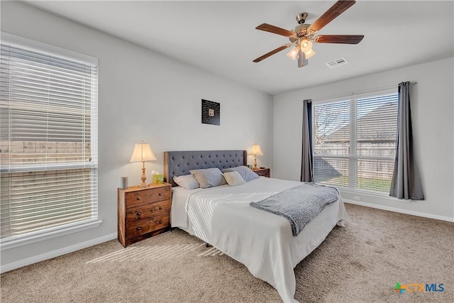 carpeted bedroom featuring visible vents, ceiling fan, and baseboards