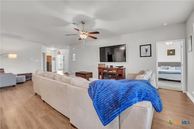 living area with visible vents, light wood-style flooring, and a ceiling fan