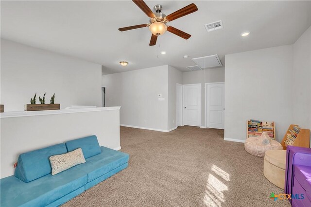 sitting room featuring visible vents, a ceiling fan, carpet flooring, baseboards, and attic access