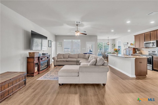 living area featuring recessed lighting, light wood-style floors, visible vents, and ceiling fan