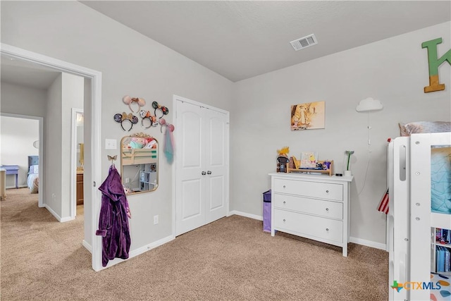 bedroom with visible vents, light carpet, baseboards, and a closet