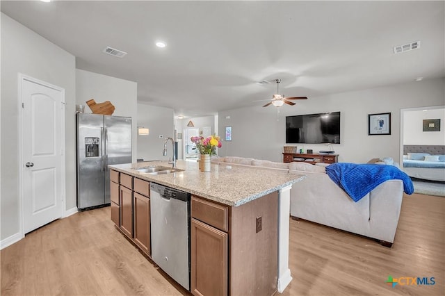 kitchen with visible vents, light wood-type flooring, stainless steel appliances, a ceiling fan, and a sink