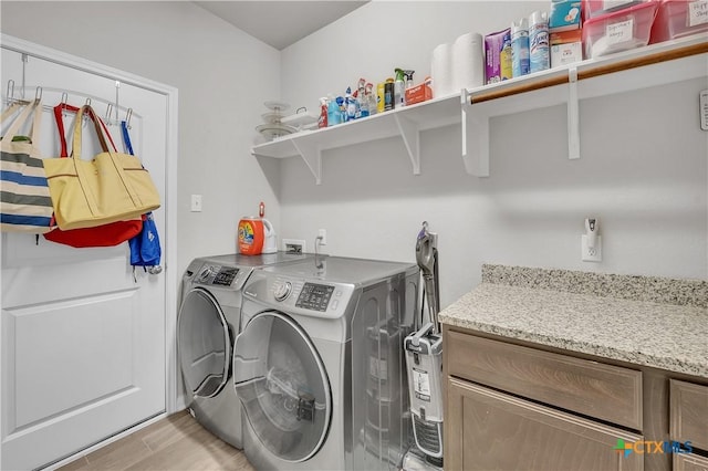 washroom with laundry area, light wood-style flooring, and washing machine and clothes dryer