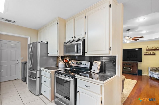 308 Green Gable Dr, Victoria, TX 77904 - kitchen featuring stainless steel appliances, ceiling fan, open floor plan, decorative backsplash, and dark countertops