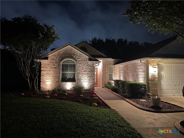 308 Green Gable Dr, Victoria, TX 77904 - ranch-style house with stone siding, an attached garage, and a yard