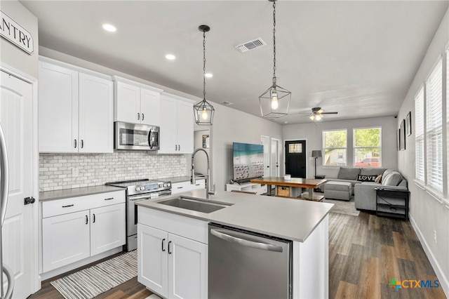 964 Allende St, Seguin, TX 78155 - kitchen with stainless steel appliances, a sink, a ceiling fan, a center island with sink, and backsplash