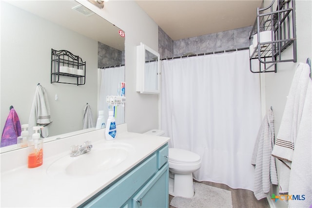 bathroom with a shower with shower curtain, vanity, and toilet