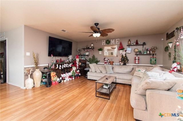 living area featuring a ceiling fan, wood finished floors, and visible vents