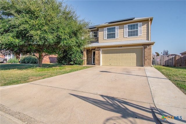 view of front of house with an attached garage, brick siding, and a front yard