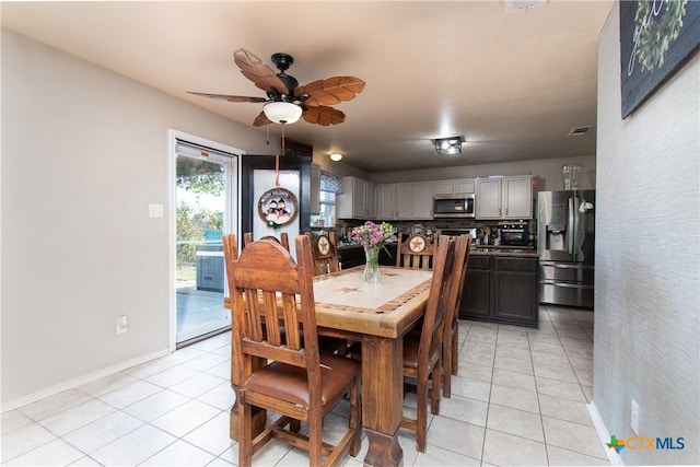 dining room featuring light tile patterned flooring, visible vents, baseboards, and ceiling fan
