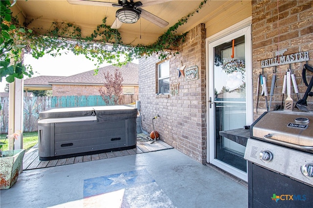 view of patio featuring grilling area, ceiling fan, and a hot tub