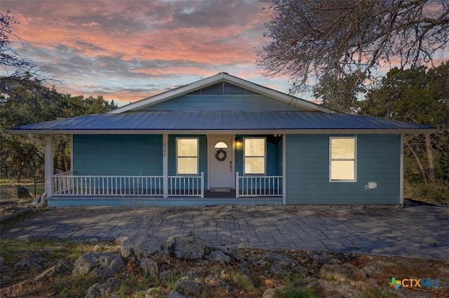 view of front of house featuring covered porch and metal roof