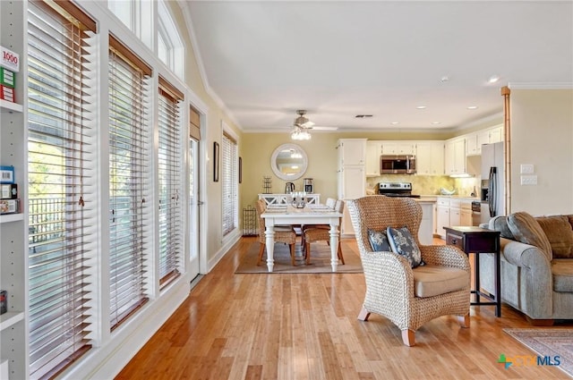 living room featuring recessed lighting, light wood-style flooring, crown molding, and a ceiling fan