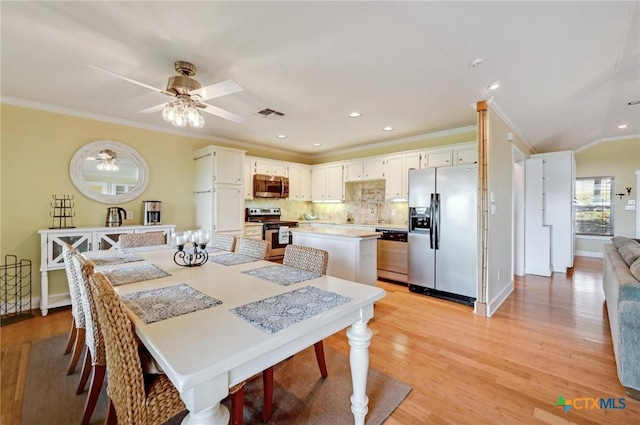 dining room with visible vents, light wood-style flooring, and ornamental molding