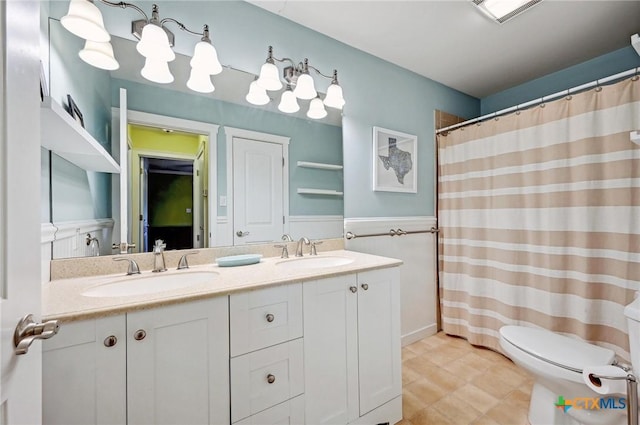 full bath featuring double vanity, toilet, visible vents, and a sink