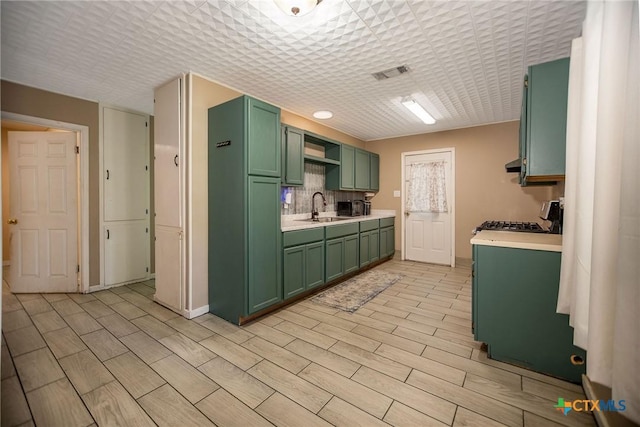2102 Leon Dr, Port Lavaca, TX 77979 - kitchen featuring green cabinetry, light countertops, range, and tasteful backsplash