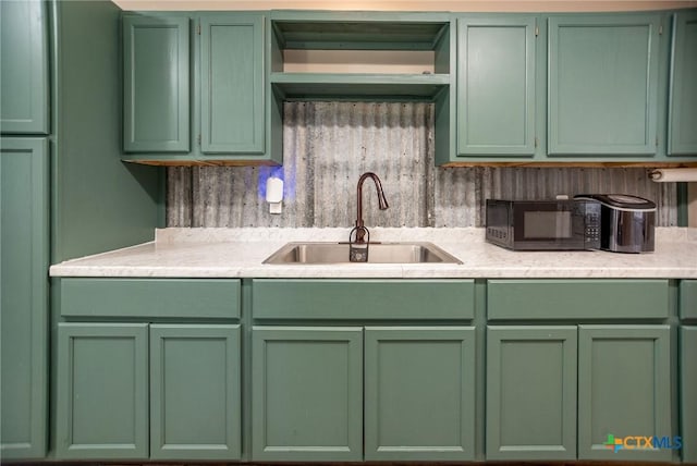 2102 Leon Dr, Port Lavaca, TX 77979 - kitchen featuring green cabinetry, light countertops, and black microwave