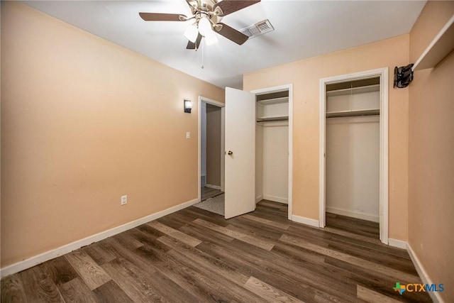 2102 Leon Dr, Port Lavaca, TX 77979 - unfurnished bedroom featuring two closets, dark wood-style flooring, and ceiling fan