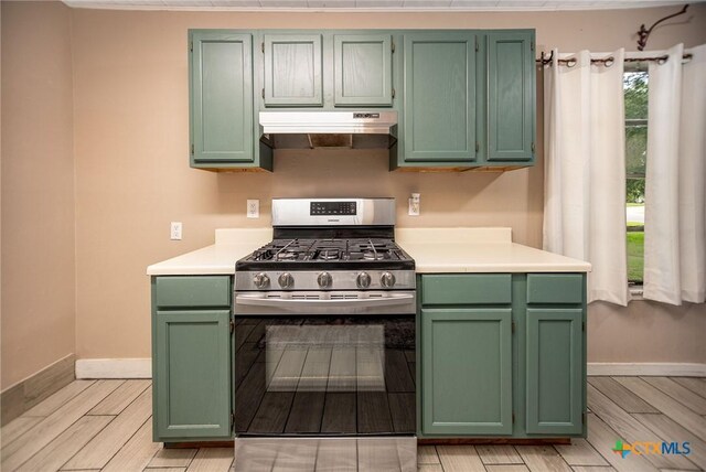2102 Leon Dr, Port Lavaca, TX 77979 - kitchen featuring gas range, under cabinet range hood, green cabinets, light countertops, and light wood finished floors