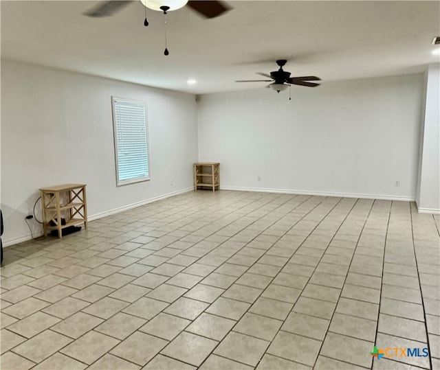 spare room with ceiling fan and light tile patterned floors