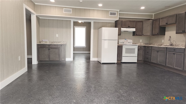 kitchen featuring crown molding, wooden walls, sink, white appliances, and ceiling fan