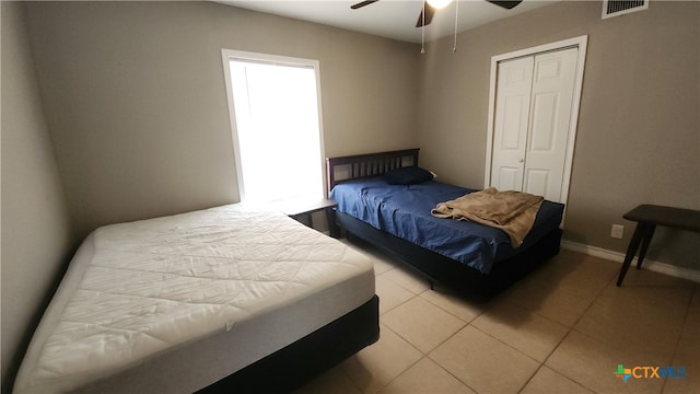 tiled bedroom featuring ceiling fan and a closet