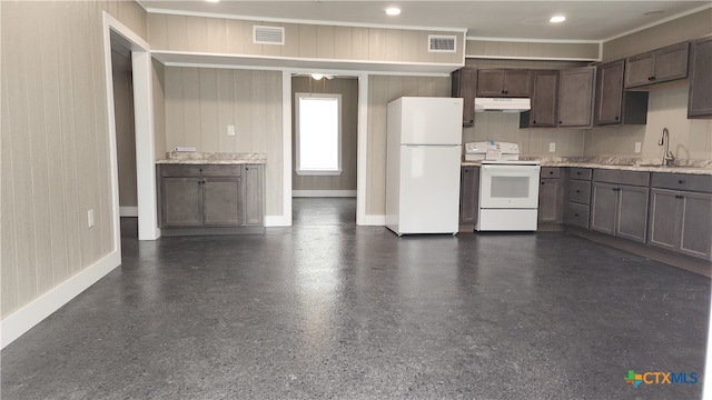 kitchen featuring sink, light stone countertops, ceiling fan, white appliances, and wooden walls