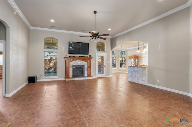 unfurnished living room with a ceiling fan, a healthy amount of sunlight, and crown molding