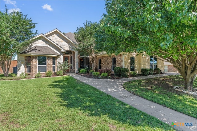 view of front of house featuring brick siding and a front lawn