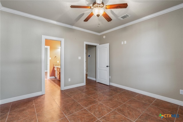 empty room with visible vents, ornamental molding, baseboards, dark tile patterned flooring, and ceiling fan