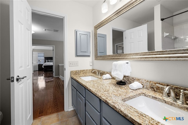 25039 Arrow Gln, San Antonio, TX 78258 - full bath featuring double vanity, ensuite bathroom, a tile shower, baseboards, and toilet