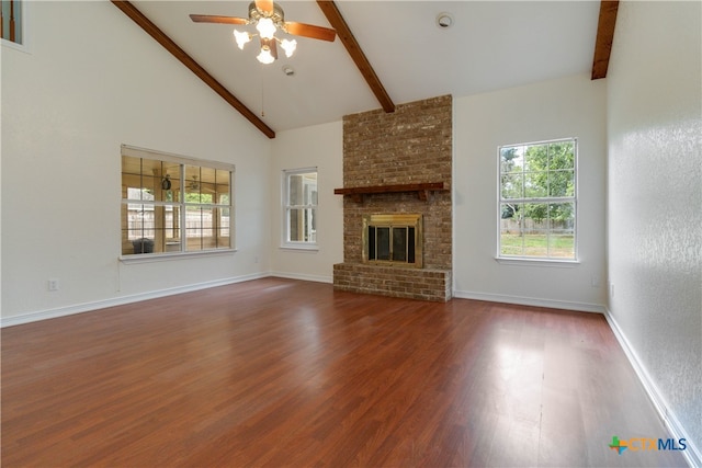 unfurnished living room with high vaulted ceiling, hardwood / wood-style flooring, a brick fireplace, beamed ceiling, and ceiling fan