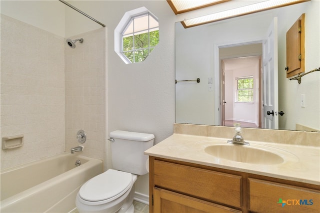 full bathroom with toilet, vanity, tiled shower / bath, and plenty of natural light