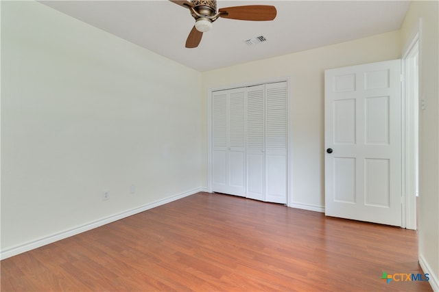 unfurnished bedroom featuring hardwood / wood-style flooring, ceiling fan, and a closet