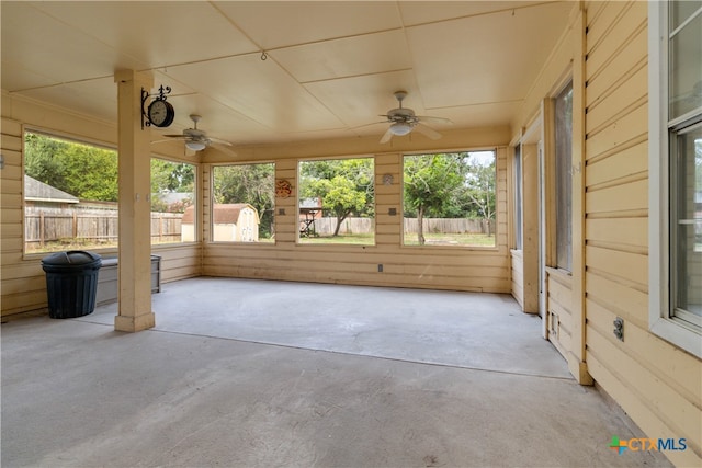 unfurnished sunroom featuring ceiling fan