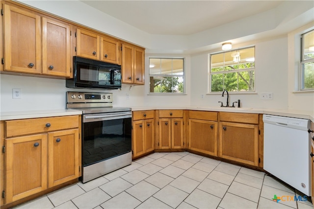 kitchen with stainless steel range with electric stovetop, a healthy amount of sunlight, white dishwasher, and sink