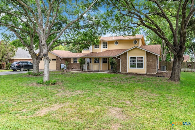 view of front of house featuring central air condition unit, a garage, and a front yard