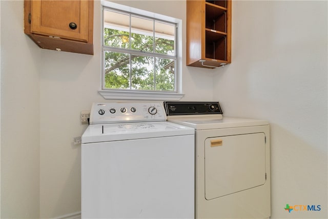 laundry area with cabinets and washing machine and clothes dryer