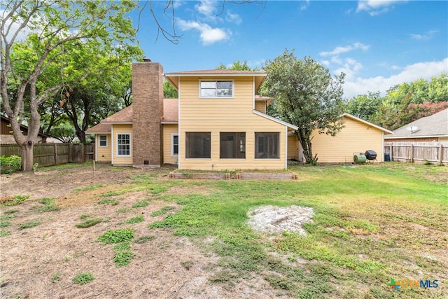 back of house featuring a lawn