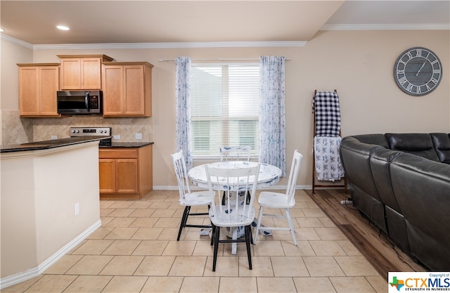 kitchen featuring ornamental molding, electric range oven, backsplash, and a breakfast bar