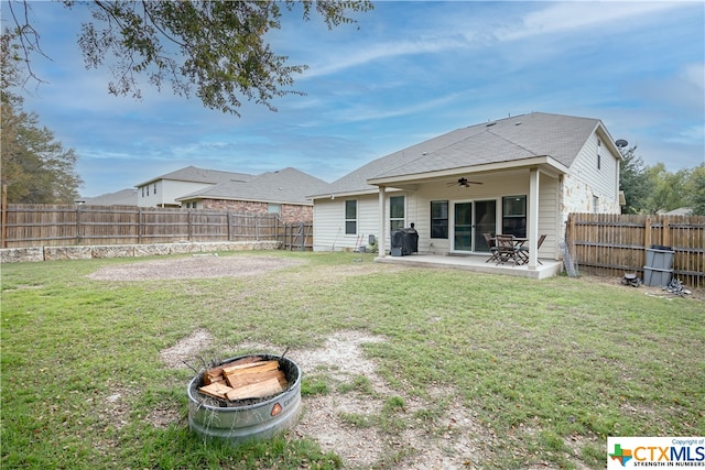 back of property featuring ceiling fan, a lawn, and a patio area