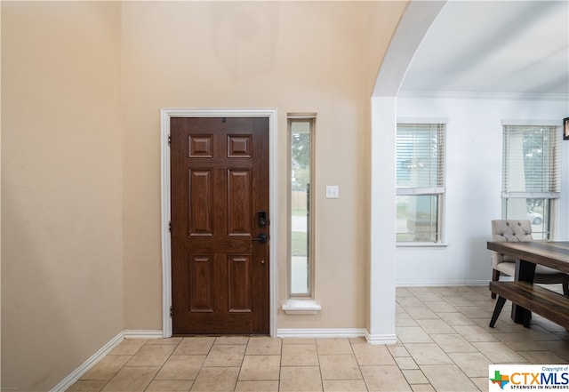 tiled foyer entrance with ornamental molding