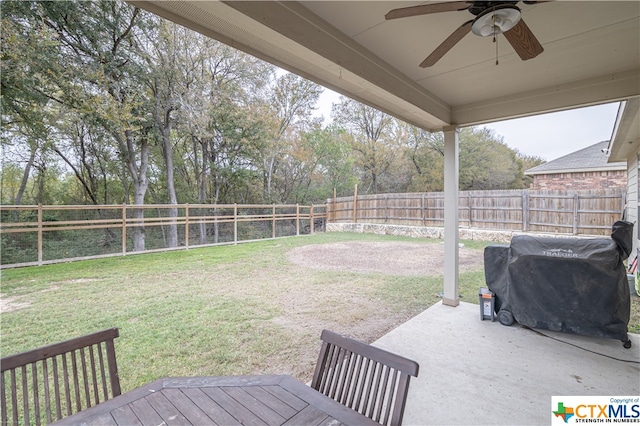 view of yard with ceiling fan and a patio area