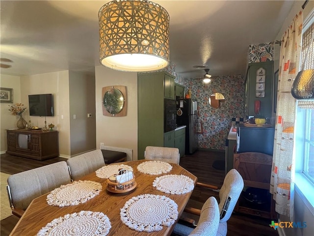 dining area with wallpapered walls, wood finished floors, and baseboards