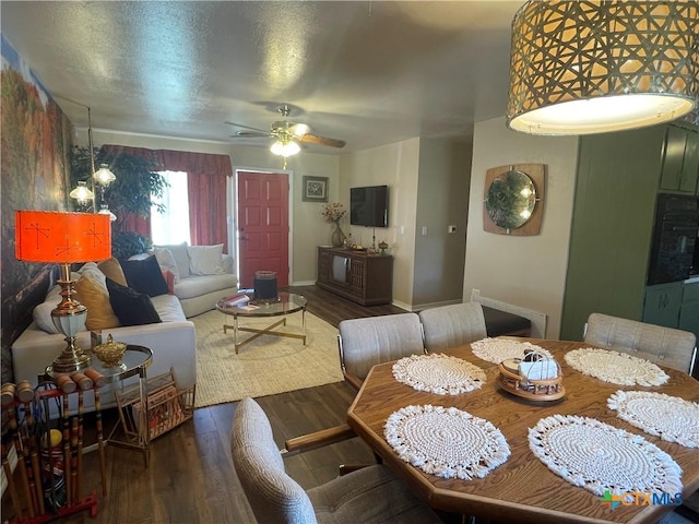 dining room featuring ceiling fan, baseboards, a textured ceiling, and wood finished floors