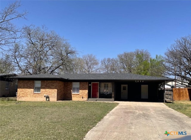 ranch-style house with a front lawn, concrete driveway, fence, and brick siding